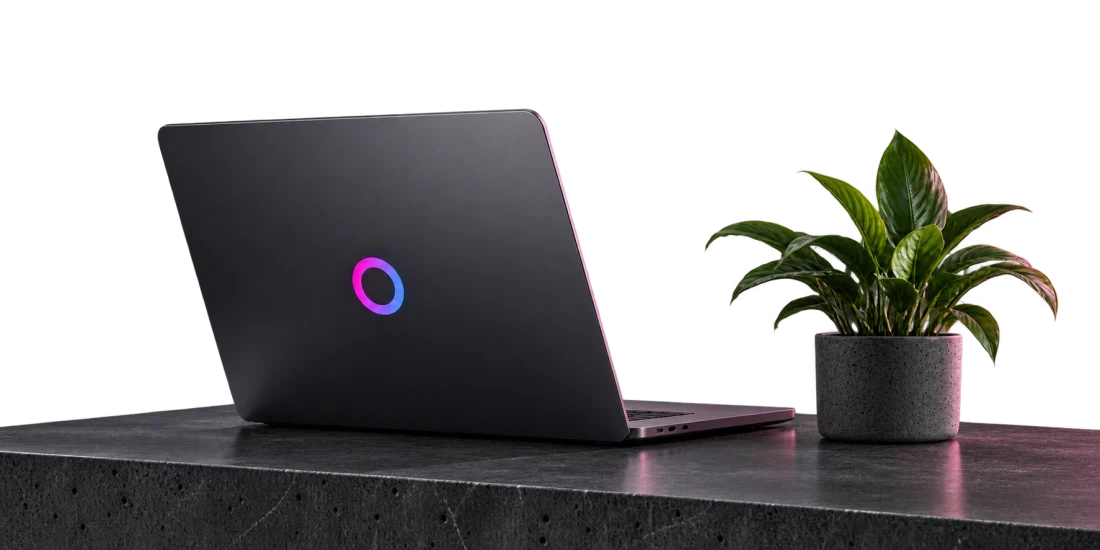 An Omnixco laptop in a softly lit charcoal studio