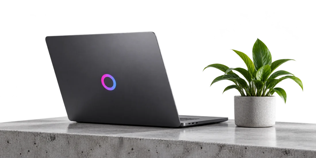 A premium Omnixco laptop and plant on a minimal studio desk